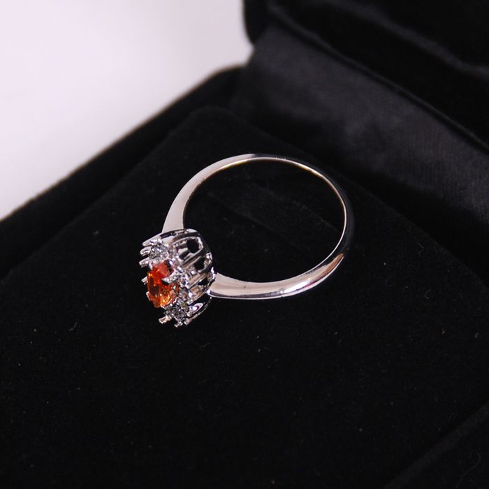 Sparkling silver ring studded with orange sto